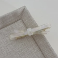 Detail einer cremefarbenen Acetat-Schleifen-Haarspange mit goldener Enkel-Clip-Basis - Lang-Meerjungfrau Weiß