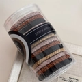 Detail view of woven high-elastic hair ties in neutral earth tones in clear cylinder box - Coffee & Black