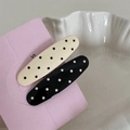 Close-up of black and white polka dot hair clips on a soft pink decorative card - Thick Bar Clip