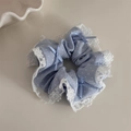 Vue détaillée du chouchou bleu clair à pois avec bordure en dentelle et nœuds doux - Bleu