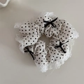 Détail d'un chouchou blanc à pois avec bords en dentelle et petits nœuds noirs - Blanc