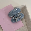 Détail de barrettes en denim bleu avec strass brillants et un nœud élégant en relief - Denim Étoilé - Pince Ovale Bleu Clair