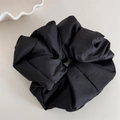 Close-up of large black fluffy fabric scrunchie showing detailed textile texture - Black