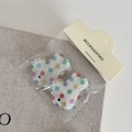 Gros plan de pinces à cheveux lapin avec pois colorés sur un fond en tissu texturé - Lapin / Pois Colorés