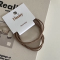 Detail of high-elastic brown hair ties on a Hansy brand display card for daily use - Brown