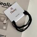 Close-up of black high-elastic hair ties on display card with a minimalist aesthetic - Black