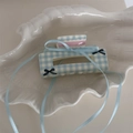 Dettaglio del fermaglio per capelli a quadretti blu con fiocco in nastro azzurro - Stile Gingham Blu Bianco