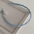 Détail de serre-tête ondulé bleu Morandi avec dents antidérapantes et une finition mate chic - Bleu