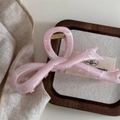Dettaglio macro di una grande pinza per capelli a farfalla marmo rosa con molla dorata - Motivo marmo rosa