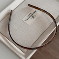 Detail of tortoiseshell acetate headband showing inner grip teeth and polished finish - Blue Coffee
