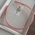 Cerchietto rosa traslucido in acetato con denti antiscivolo su una scatola beige lino - Rosa