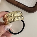 Detalle de coletero de metal dorado con textura martillada y cordón elástico negro fuerte - Cuerda de Pelo Martillada de Doble Capa-Dorado