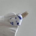 Detailweergave van hartvormige haarclip met blauw marmeren acetaat en logo-opdruk - Beige Blauw
