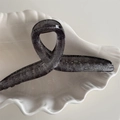 Close-up of a charcoal grey translucent hair claw clip with silver glitter and curved design - Hanger Style / Black