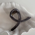 Detail of elegant black translucent hair claw with silver glitter and gold metal spring - Cross Loop Style / Black