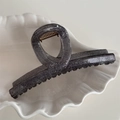 Close-up of a dark grey glitter hair claw clip with a strong gold spring on white ceramic - Criss-cross Flat Style / Black