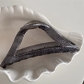 Macro detail of charcoal grey glitter triangle hair claw clip on a white shell tray - Triangle Style / Black