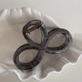 Detailed close-up of a graphite grey glitter bow hair claw clip with a gold metal spring - 8-Shape Style / Black