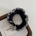 Detailed view of black scrunchie with houndstooth lace trim and a glossy buckle detail - Black White Plaid Lace-Black