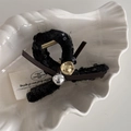 Close-up of black sequin hair claw with a bow and metallic beads on a white tray - Black Sequin Silver Bead - Hair Claw