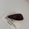 Detailed view of amber acetate hair clip with polished finish on beige linen backdrop - Dark Coffee