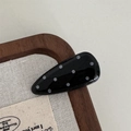 Close-up of a teardrop-shaped black hair clip with white polka dots on a wooden surface - Water Drop Hair Clip / Black