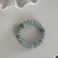 Vue détaillée de l'élastique spirale avec motif de marbre gris et fini transparent - Gris Bleu Dégradé