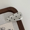 Detailed view of a cream waterdrop hair clip with black polka dots on a display tray - Water Drop Hair Clip / White