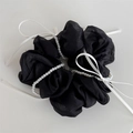 Dettaglio dell'elastico in organza nera con fili di perle bianche e nastri raffinati - Nero