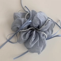 Dettaglio macro di un elastico per capelli in raso lilla con perle e nastri - Azzurro