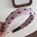 Gros plan détaillé du serre-tête rose en éponge avec motifs nœuds et étiquette faite main - Serre-tête Rose Nœud - Large
