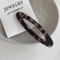 Macro view of a tortoiseshell leopard print oval hair clip on a ceramic display - Light Tortoise - Hollow Oval