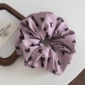 Détail d'un chouchou plissé lilas avec des motifs de nœuds et texture du tissu - Chouchou Rose - Nœud