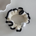 Vista dettagliata di un elastico per capelli a balze bianco e nero con perla opaca grande - Stile Perla - Beige