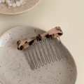Dettaglio ravvicinato di un pettine per capelli a fiocco in acetato leopardato su vassoio - Tartarugato Chiaro