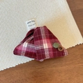 Close-up of red plaid fabric hair claw with vintage buttons on a rustic texture - Red
