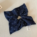 Close-up of navy blue floral scrunchie with fabric label and small metal pendant - Navy Blue Scarf Scrunchie
