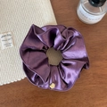 Détail d'un chouchou en satin violet, texture soie avec petit pendentif doré décoratif - Violet