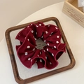 Detail of burgundy polka dot scrunchie with ruffled edges in a wooden display tray - Red Polka Dot