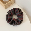 Detail eines grau-rot gestreiften Strick-Scrunchies mit Lagenoptik und weichen Falten - Grau Kaffee