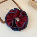 Dettaglio dell'elastico per capelli rosso scuro con bordi in denim blu su sfondo vintage - Rosso