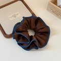 Dettaglio di un elastico in raso marrone vintage con bordo stile denim blu - Marrone