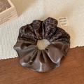 Detail of leopard print and brown leather patchwork scrunchie with woven tag - Brown Leopard