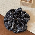 Dettaglio dell'elastico per capelli in velluto nero con pois bianchi e motivi a quadretti - Scrunchie