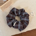 Dettaglio dell'elastico per capelli a scacchi marroni con etichetta Hand Made - Grigio