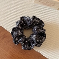Dettaglio dell'elastico per capelli nero a scacchi bianchi su tappetino beige - Scrunchie a Doppio Strato