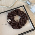 Detailansicht des braunen Stoffhaargummis mit Blumenmuster, handgefertigtem Etikett - Braun Blumen Scrunchie