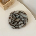 Gros plan sur un chouchou en fausse fourrure à imprimé tigre avec texture pelucheuse douce - Brun Olive