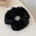 Détail d'un chouchou en velours noir avec bordure à motif floral vintage et texture superposée - Noir Imprimé