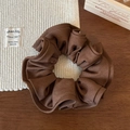 Close-up of brown ruffled fabric scrunchie with glossy texture on a vintage background - Dark Coffee